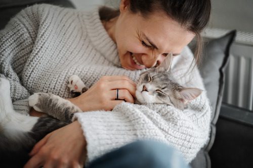 female-owner-holding-gray-and-white-cat